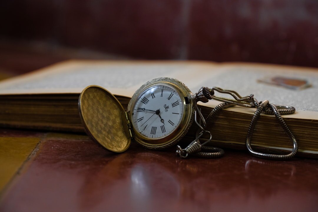Antique pocket watch resting on an old book
