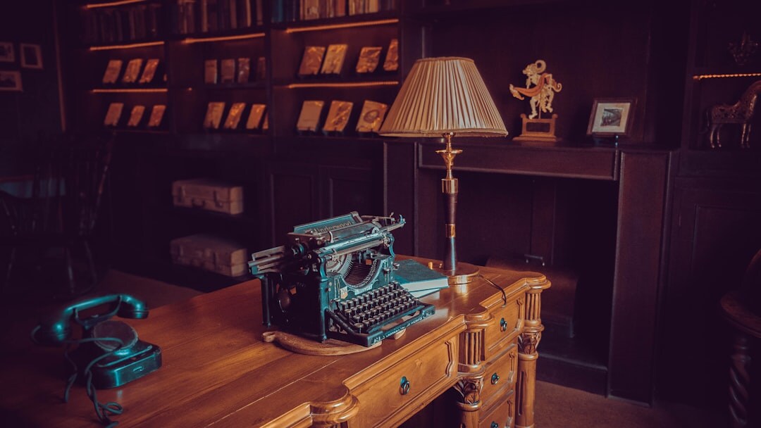 Vintage writing desk with an open detective novel, magnifying glass and typewriter